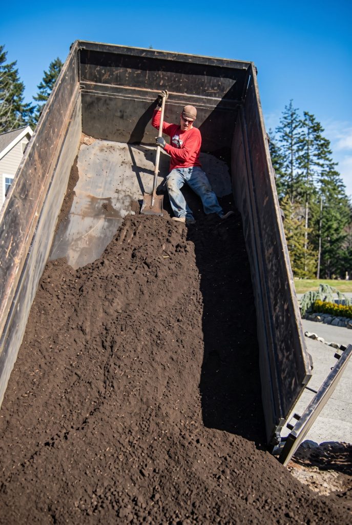 A Blue Meadow Landscaping dump truck delivers soil & gravel to a local Greater Victoria property.